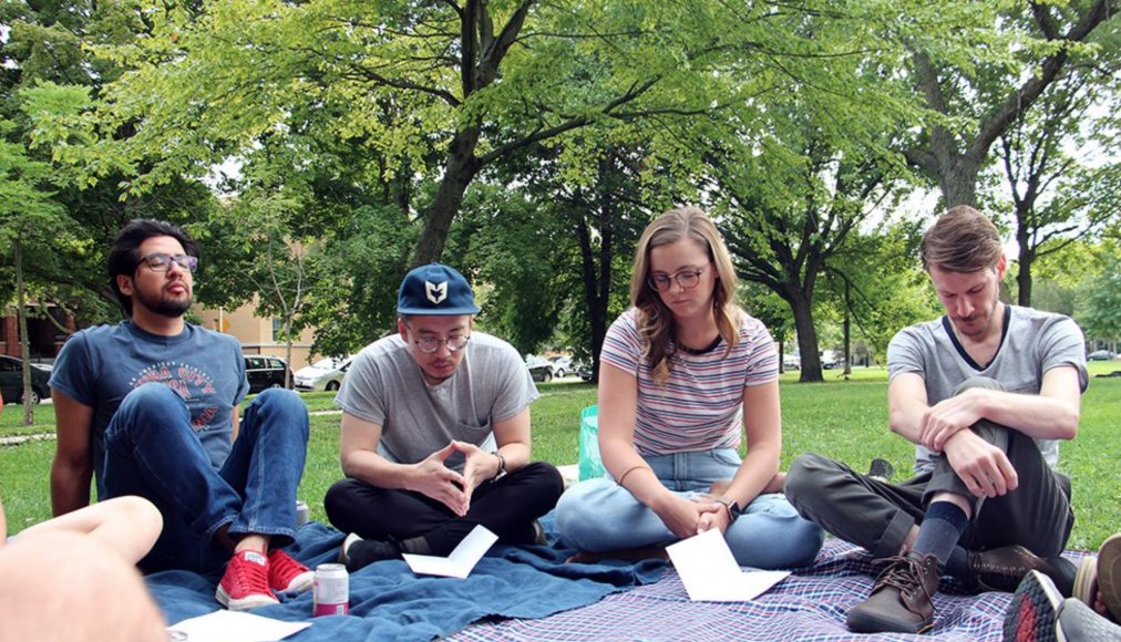 Le pasteur Tim Kim (au centre), des membres et invités de l'Eglise Root & Branch Church se rassemblent pour un service d'Eglise à table, le 25 août 2019, au Palmer Square Park à Chicago. Le pasteur Tim Kim (au centre), des membres et invités de l'Eglise Root & Branch Church se rassemblent pour un service d'Eglise à table, le 25 août 2019, au Palmer Square Park à Chicago. / RNS